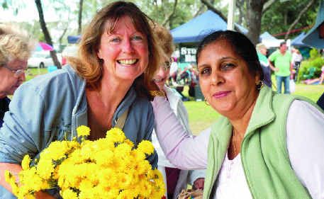 Chris Mayers buying chrysanthemums for her mother from Randhir Hundal at the Jetty Markets.